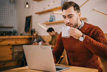 帅的男人喝咖啡在咖啡馆背景图片