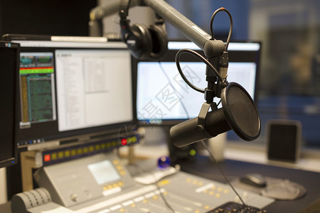 广播电台演播室混音器和电脑前的麦克风图片