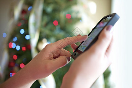 圣诞节的智能手机玩新的智能手机礼物女手背图片