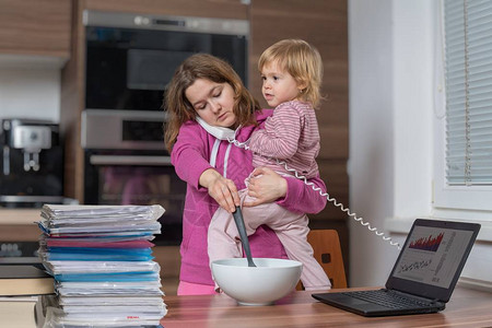 多任务母亲负责照看孩子和在家工作图片