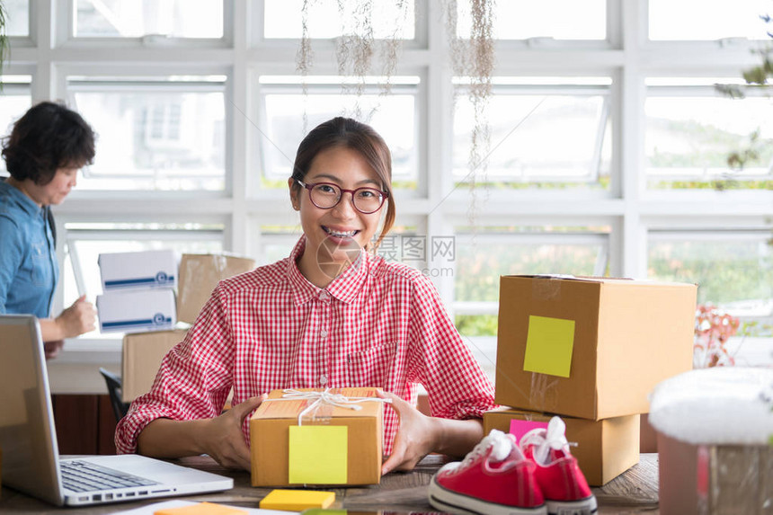 年轻的小企业主在工作场所包装纸板箱自由女企业家SME卖家准备产品包裹盒以交付给客户网上销售网络营销电子商图片