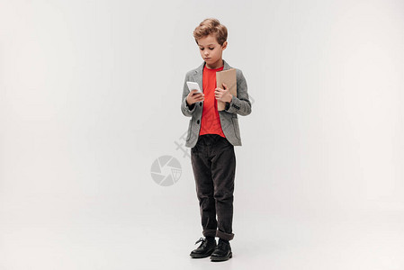 有智能手机和书本的时尚小男孩图片
