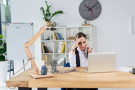 陷入困境的女商人坐在办公桌前的办公室里图片