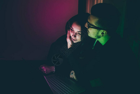 使用计算机室内黑暗的年轻美貌夫妇技术网上购物社交网图片