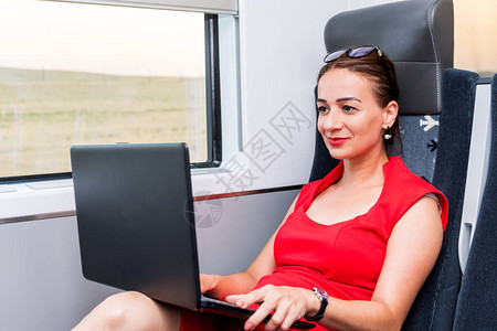 在火车上用笔记本电脑工作的女商业图片