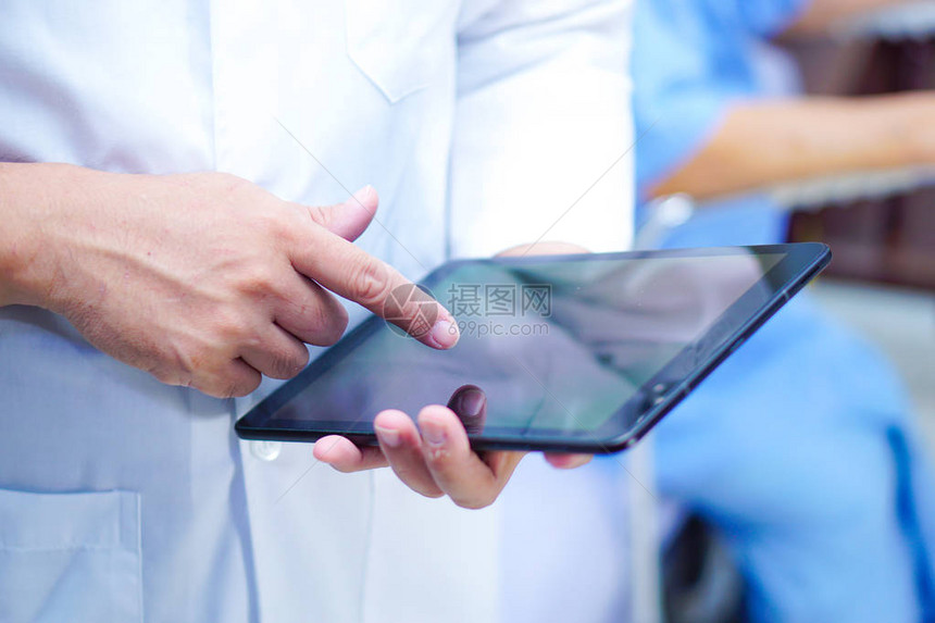 亚洲智能男医生手持数字平板技术搜索知识解决护理医院病房患者的治疗图片