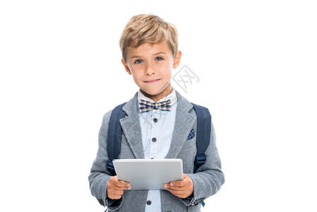 带着数字平板电脑的笑着男孩在背景图片