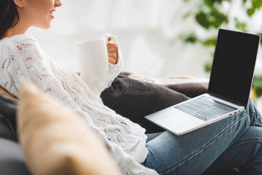 在笔记本电脑上用空白屏幕观看电影的咖啡杯女图片