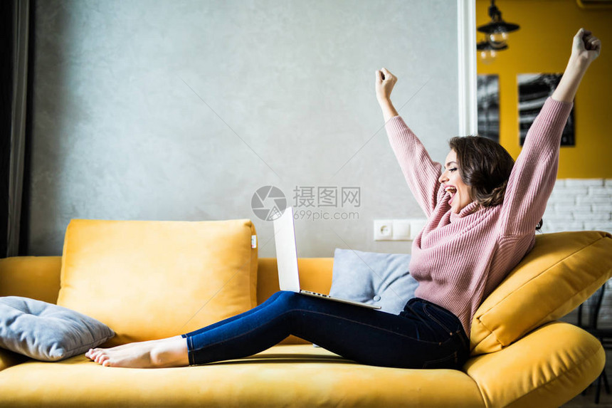 女人举起手在沙发上举起手在家中图片