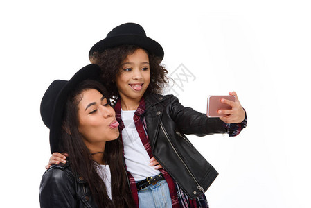 时尚的母亲和女儿用智能手机自拍图片