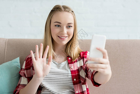青少年女学生用智能手机和相机挥手进行视频通话的近图片