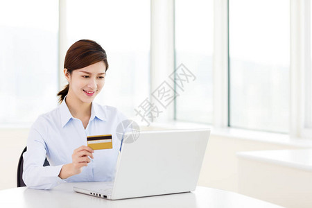 商务女性使用信用卡和电脑图片