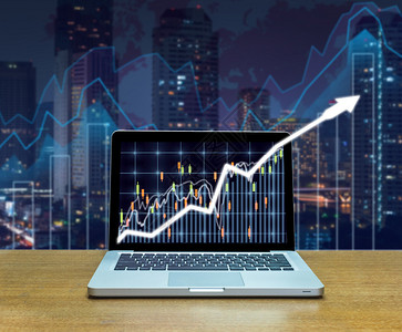 木桌上电脑笔记本电脑屏幕上的证券交易所市场交易图图片