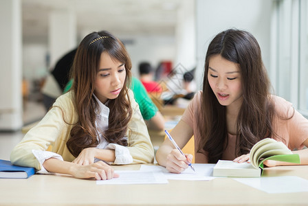 在图书馆工作的亚洲学生背景图片