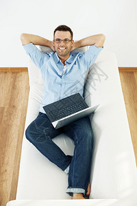 男人在沙发上用笔记本电脑和图片