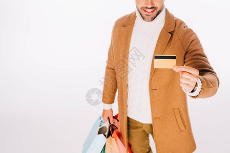 快乐的年轻人拿着信用卡和购物袋被白图片