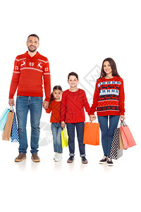 家庭穿着红色的毛衣手持购物袋在白图片