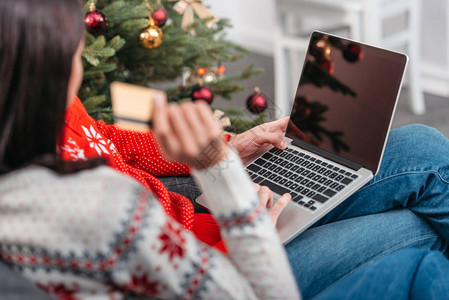 在圣诞节用信卡和笔记本电脑在网上购物的年图片