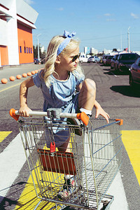 可爱的小女孩在停车场购物图片