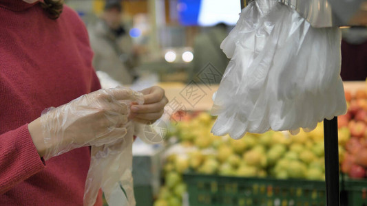 超市里的一名妇女戴上一次塑料手套图片