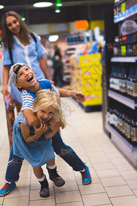 幸福的兄弟姐妹在超市玩得开心图片