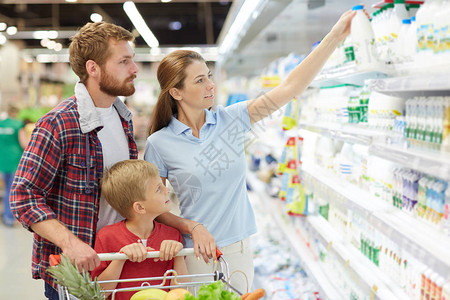 年轻家庭与孩子在超市选择乳制品的腰部肖像图片