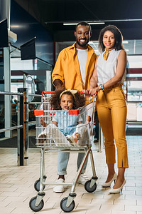 可爱的非洲裔美国孩子坐在购物车里图片