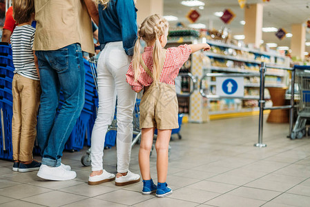 与两个孩子一起在超市购物的年轻家庭拍图片