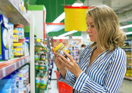 年轻女人正在超市挑选婴儿食品图片