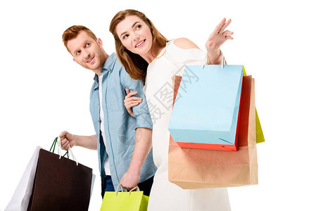 微笑的年轻夫妇拿着五颜六色的购物袋背景图片