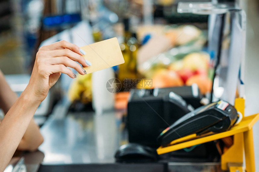 超市收银点店员手持信用卡的部分观点图片