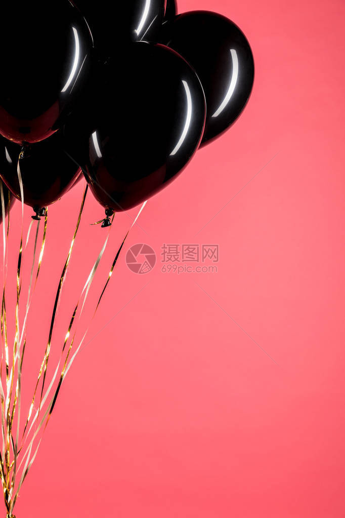 用粉红色隔离的黑色闪亮气球的特写视图图片