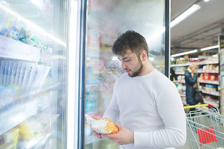 该男子在超市冰箱附近查看冷冻产品的标签超市冷图片
