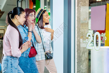 关注购物商场展示朋友购物概念的多文化时装女孩图片
