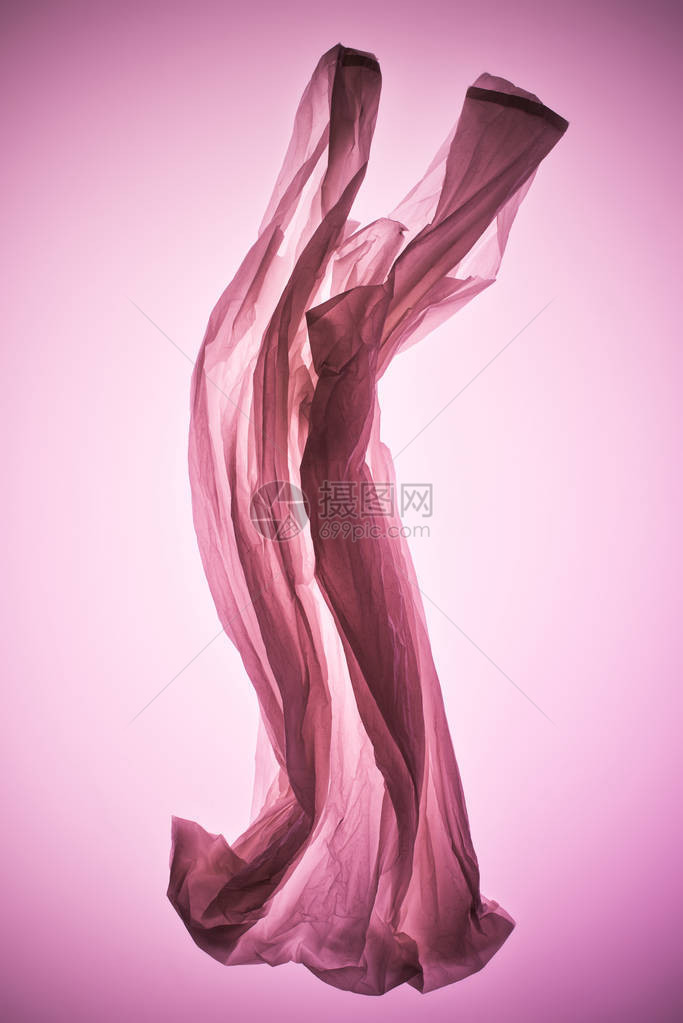 粉红色调光下的空皱巴的塑料袋图片