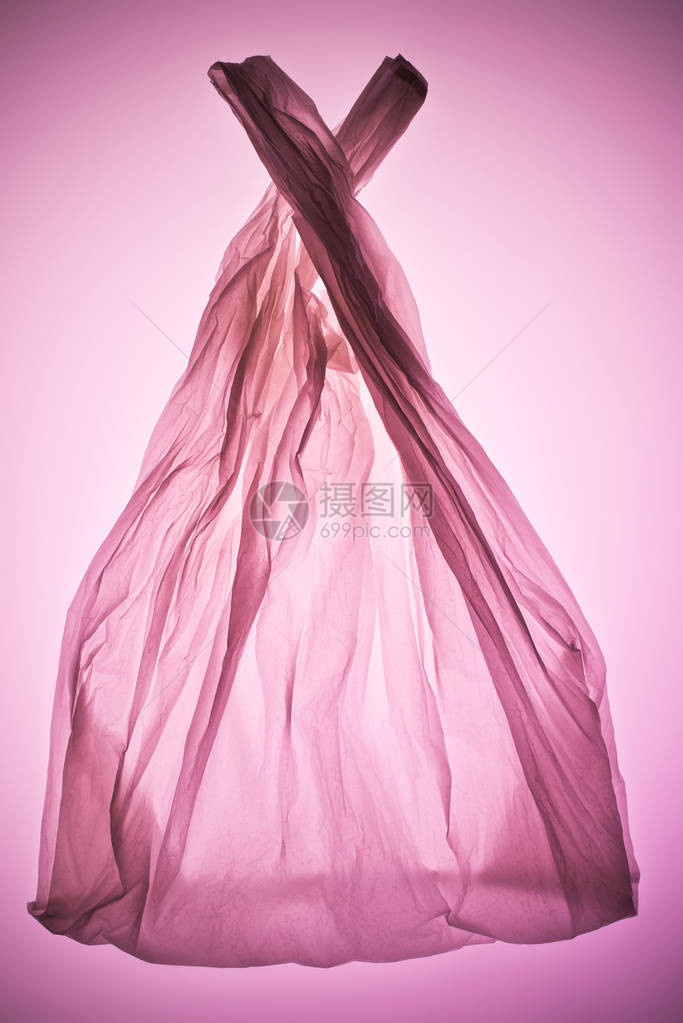 粉红色调光下皱巴的透明塑料袋图片