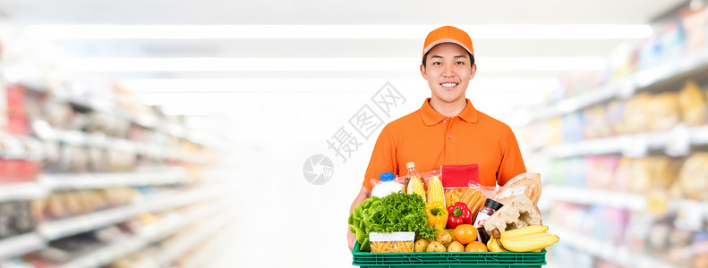 带杂货托盘的亚洲送货员在超级市横幅背景图片