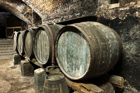 5个老的和风湿的凯格酒桶被堆在长城一排旧石图片