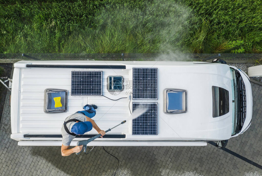 他40年代的白人男子在洗涤娱乐车辆RV露营者VanRoofEquipped配有太阳能电池板图片