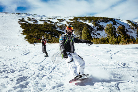 年轻人骑雪板在山坡上享受阳图片