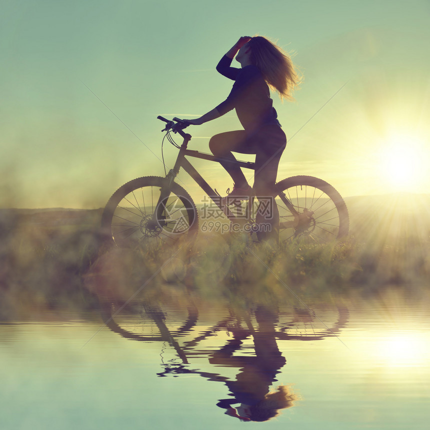 在日落时骑自行车的女孩图片