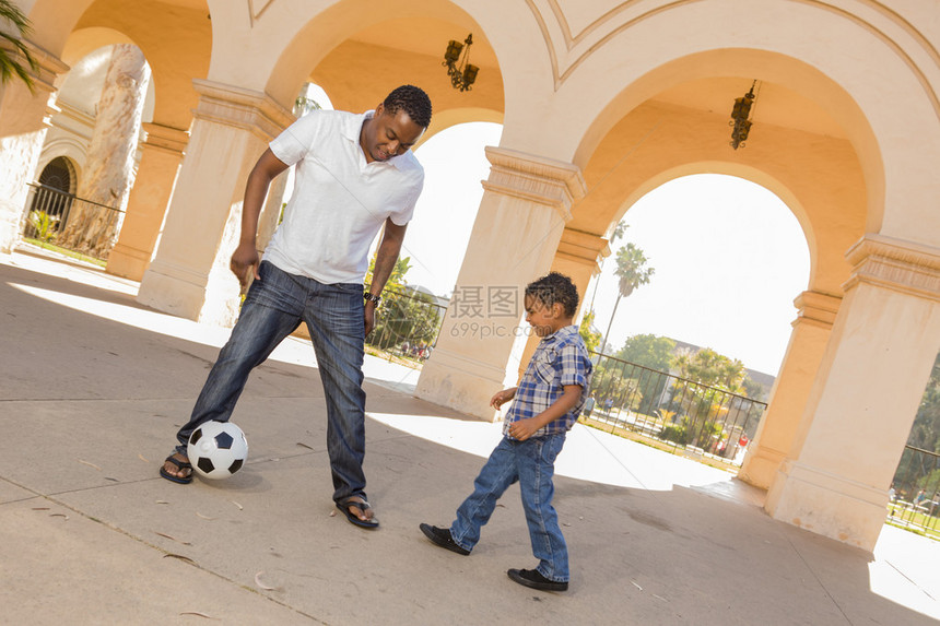 混合种族父子在庭院外面玩足球游戏图片