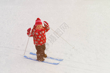 小女孩在冬天的雪中学习滑雪图片