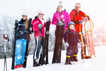 有雪橇和滑雪的家庭图片