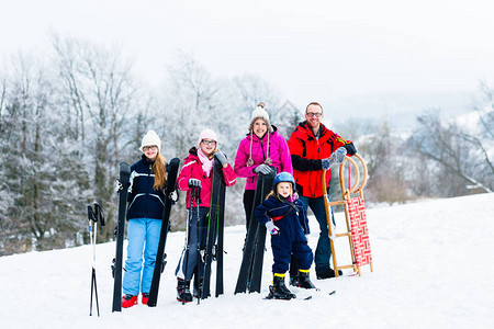 家庭在冬季度假时使用雪橇和滑雪图片