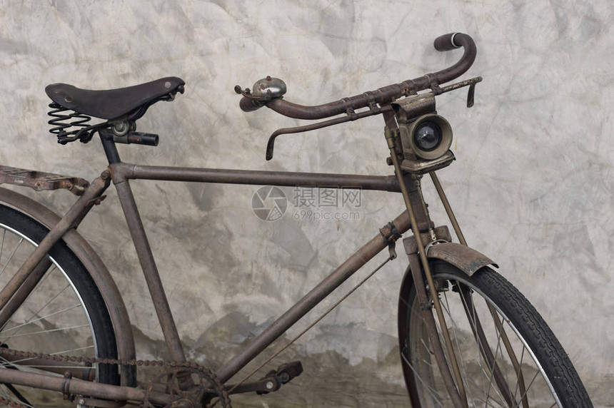 水泥墙附近的老旧自行车图片