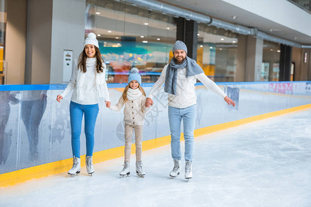 在溜冰场上一起滑冰时手牵的幸福家庭图片