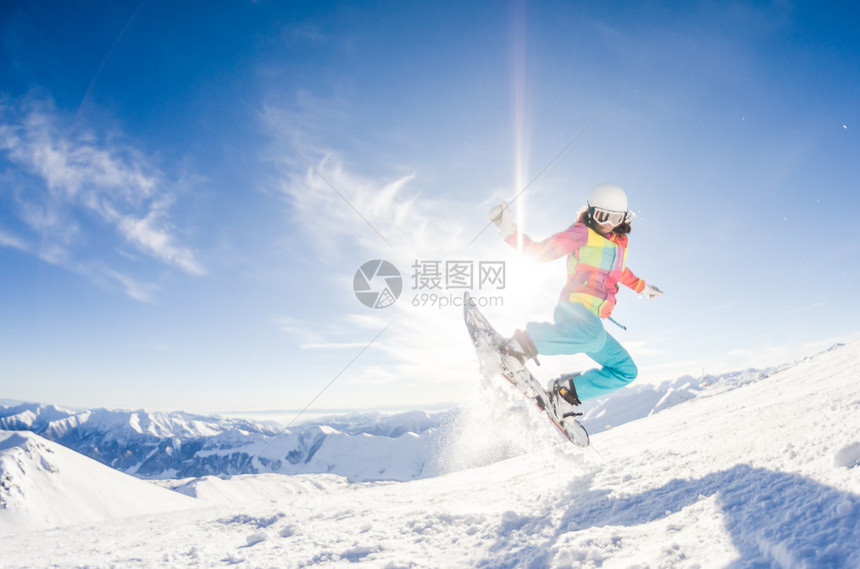 女孩在她的滑雪板跳跃中玩得开心图片