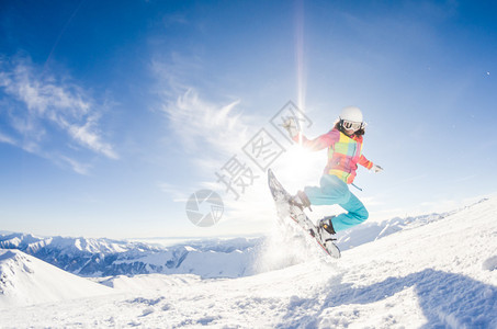 女孩在她的滑雪板跳跃中玩得开心图片
