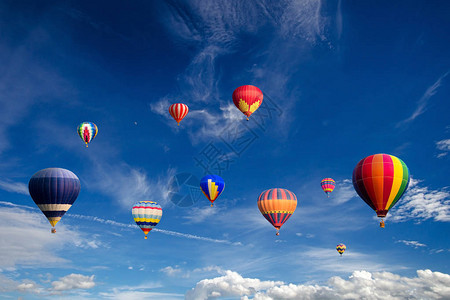 五颜六色的热气球飞过白云和蓝天图片